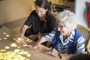 A resident and staff member interact with a magic table